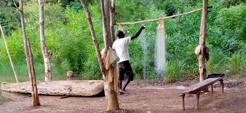 le pêcheur de la grande excavation d'eau réparant ses filet
